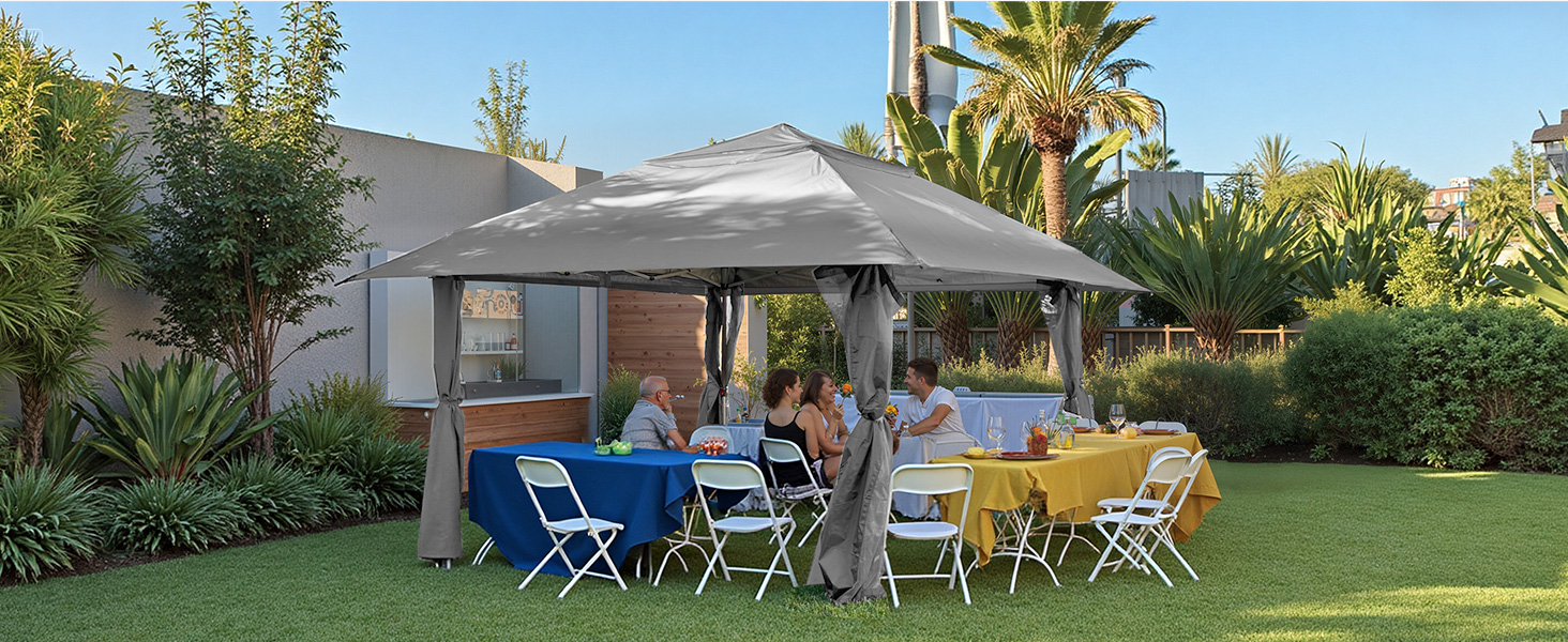 Espace événementiel extérieur avec pelouse avec chaises pliantes et tables installées, entouré d'aménagements paysagers et de plantes tropicales.