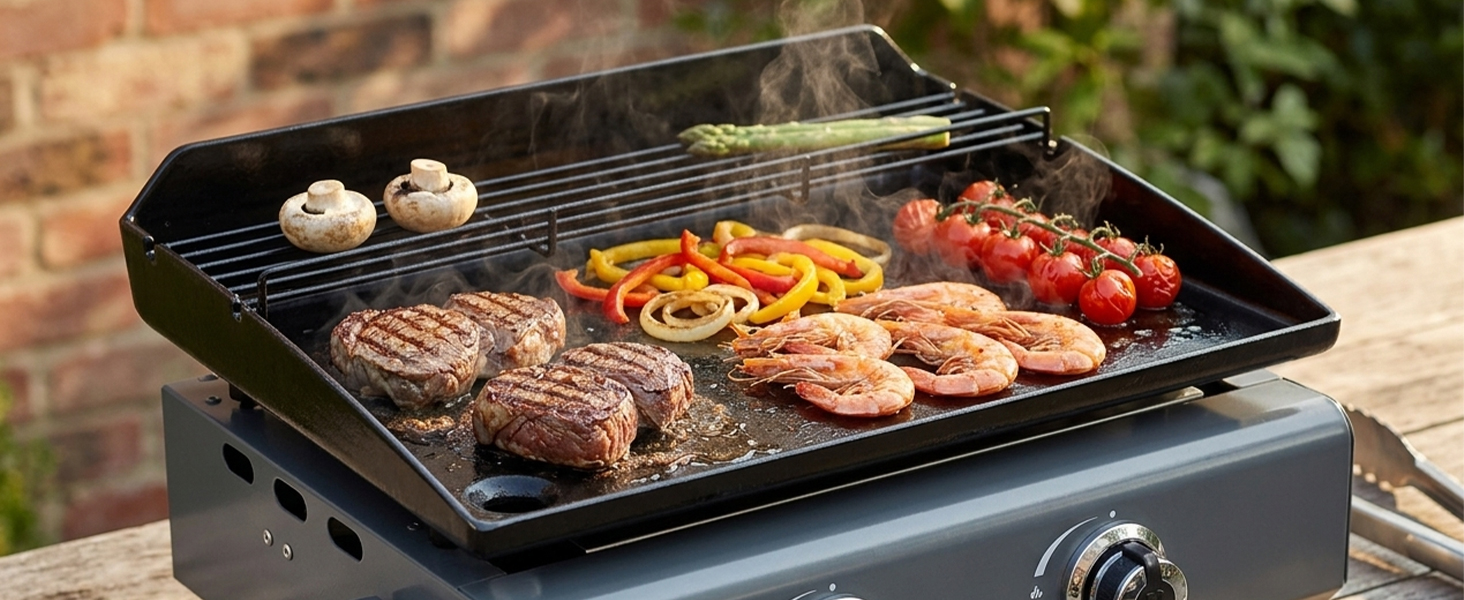 Gril à gaz portatif avec surface de cuisson noire montrant des steaks, des légumes et des tomates cerises grillés. Surface antiadhésive avec marques de gril visibles.