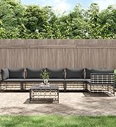 avec canapé sectionnel rembourré noir, table basse assortie et clôture d'intimité en bois. Entouré d'arbres verts dans un jardin.