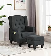 Fauteuil à ailes rembourré gris anthracite foncé avec repose-pieds ottoman assorti dans un salon lumineux. Des rideaux blancs, des plantes en pot et des meubles en bois sont visibles à l'arrière-plan.