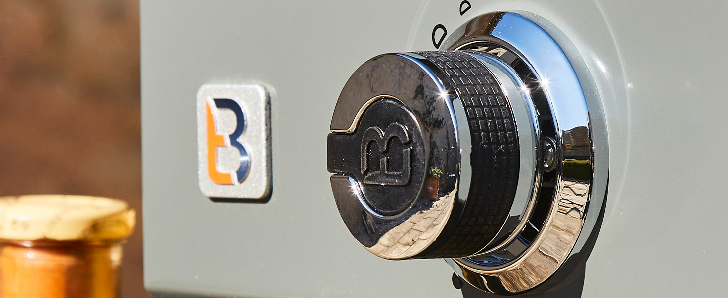 Gros plan d'un cadran de verrouillage à combinaison chromé avec un logo d'entreprise bleu-orange visible en arrière-plan.