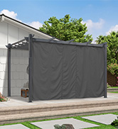 fixé à l'extérieur d'une maison, couvrant un patio. Arbres visibles en arrière-plan.