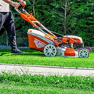 Séquence montrant une tondeuse à gazon orange et blanche en action en train de tondre le gazon par temps ensoleillé ; elle montre son fonctionnement sous plusieurs angles.