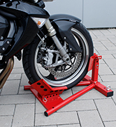 un pneu de moto est placé sur un support rouge.
