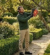 Homme dans un jardin extérieur tenant un mixeur portatif rouge, faisant la démonstration d'un appareil de cuisine portable.