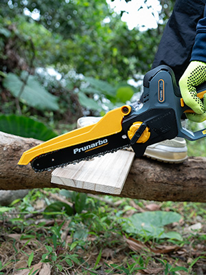 Tronçonneuse électrique avec boîtier jaune et noir utilisée pour couper une bûche de bois. L'outil semble être un modèle de marque Pruvardo doté de caractéristiques de prise de sécurité.