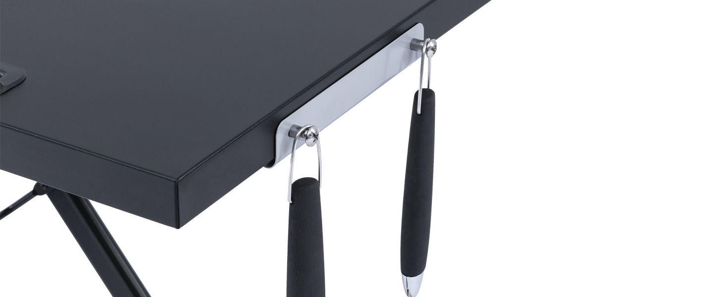 Gros plan d'un coin de bureau noir avec deux crochets métalliques attachés. Des poignées recouvertes de mousse noire sont suspendues aux crochets, probablement pour le rangement des accessoires ou la gestion des câbles
